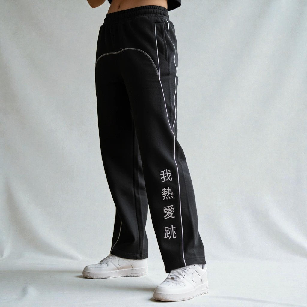 MONROE STORE pantalones de chándal negros de pierna recta con cordón, costuras blancas y texto en chino en la pierna.