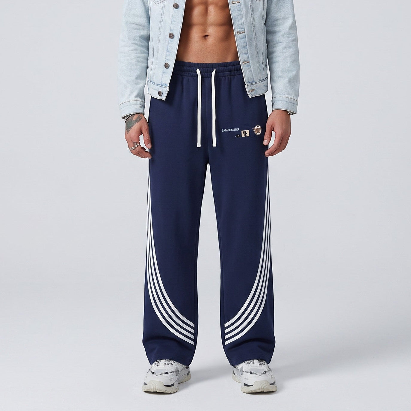 Modelo masculino con pantalones de chándal azul marino MONROE STORE con rayas curvas blancas y cordón ajustable