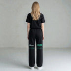 MONROE STORE pantalones deportivos negros de pierna ancha con cordón y estampado verde "WACKING DANCE"