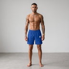 Hombre atlético vistiendo shorts deportivos azules MONROE STORE de corte holgado y tejido técnico ligero