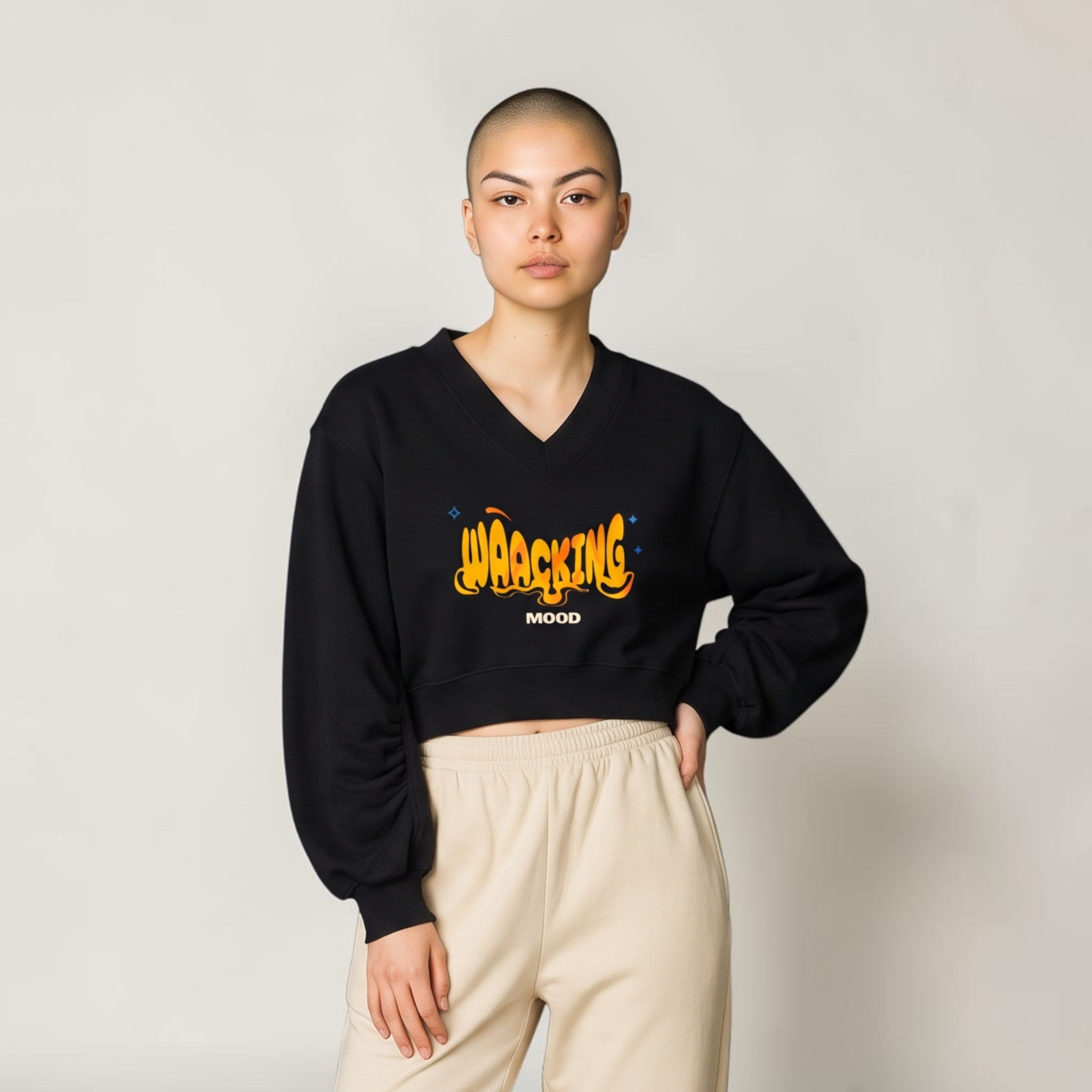 Sudadera corta negra con cuello en V y estampado gráfico de MONROE STORE combinada con pantalones deportivos beige