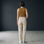 Mujer de espaldas vistiendo top corto marrón de cuello redondo MONROE STORE con pantalones beige