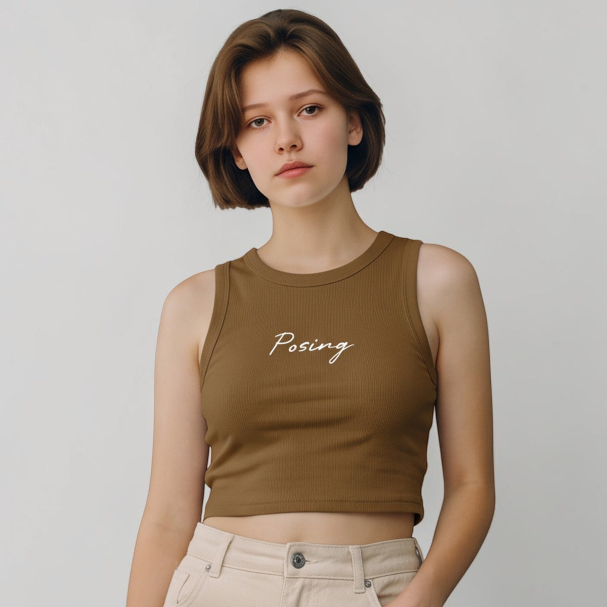Modelo con top corto ajustado MONROE STORE color marrón con cuello redondo y texto Posing en blanco